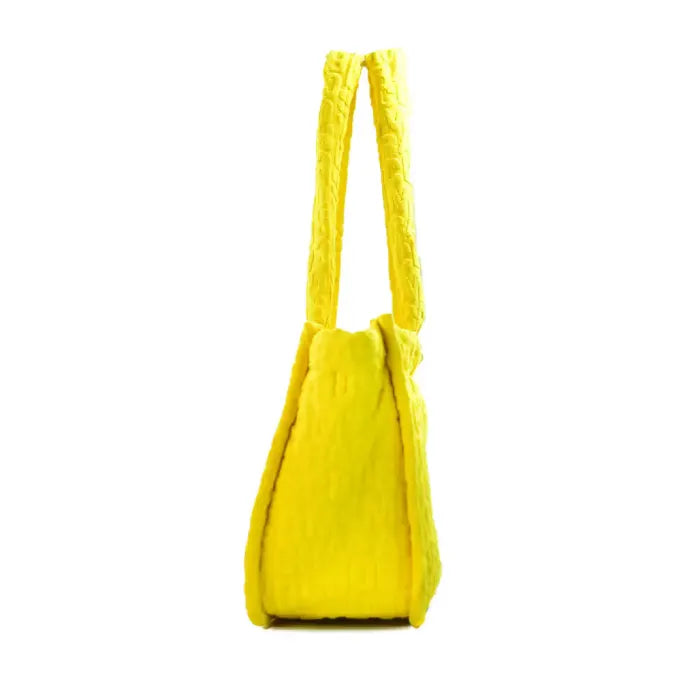 Side view of yellow Marc Jacobs tote bag with embossed logo, highlighting its slim profile and durable straps.