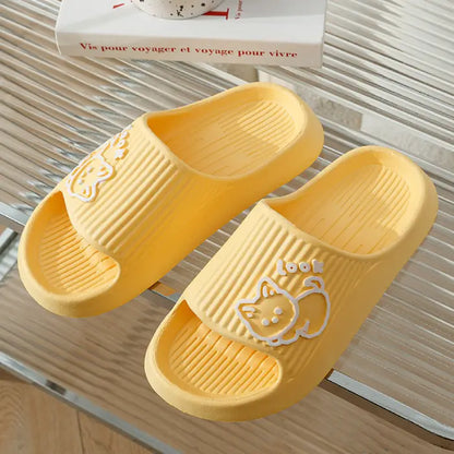 Bright yellow bathroom slides featuring white cat design displayed on striped surface