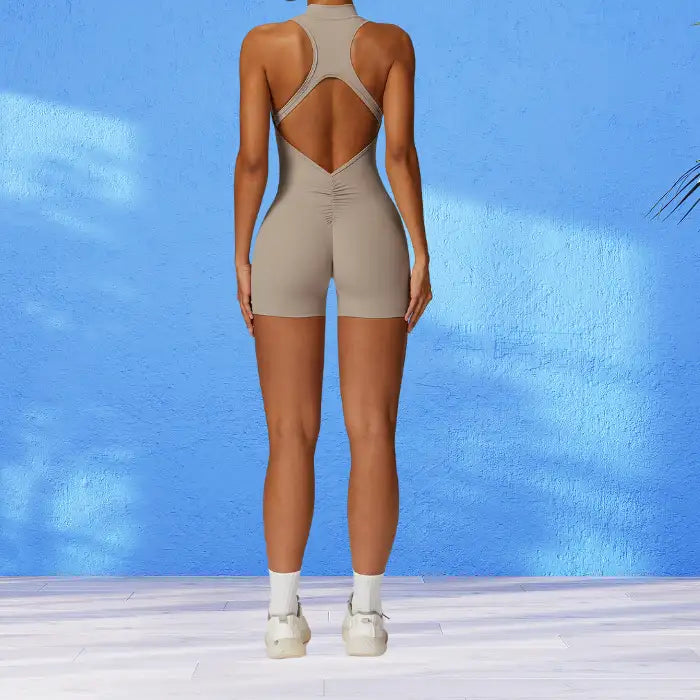 yoga bodysuit in neutral beige featuring stylish open back design with ruched detail for enhanced comfort during stretching