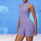 yoga bodysuit in soft lavender with zip front design against bright blue wall highlighting its sleeveless silhouette