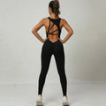 Yoga jumpsuit in classic black with open crisscross back, designed for sleek active performance.