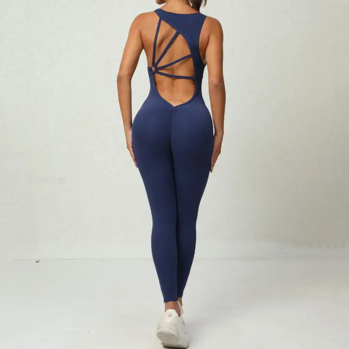  Yoga-jumpsuit in navy with deep V-back and geometric strap layout for stylish workout or gym wear.