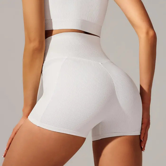 Yoga shorts set in white featuring high-waisted fit and ribbed fabric for a contoured back view.