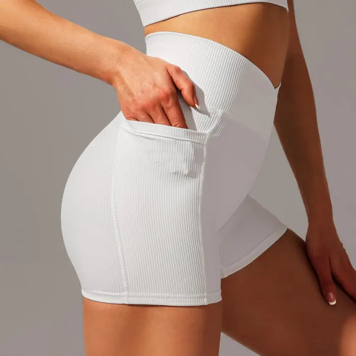 Yoga shorts set in white showing pocket detail and ribbed fabric with high-rise waistband.