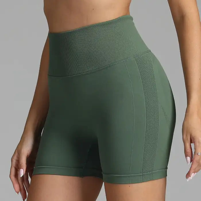 Yoga shorts women in olive green with ribbed high waist and breathable side mesh panel.