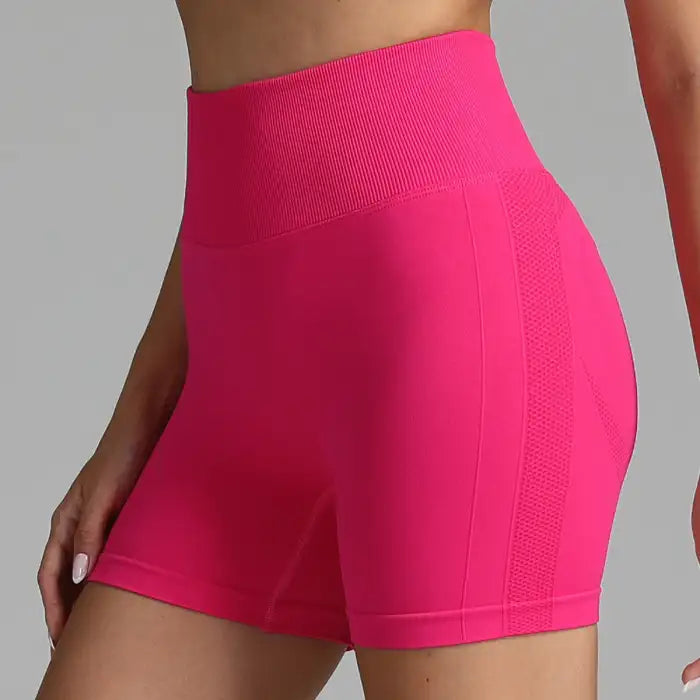 Yoga shorts women in vibrant hot pink with firm shaping waistband and side mesh panels.
