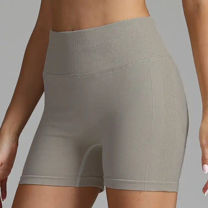 Yoga shorts women in taupe color with seamless texture and ribbed high waistband for support.