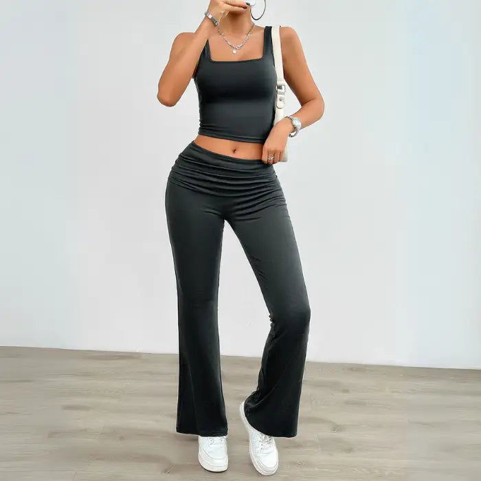 Dark gray yoga two-piece set with a cropped tank top and high-waisted flared pants, perfect for workouts or casual outings.