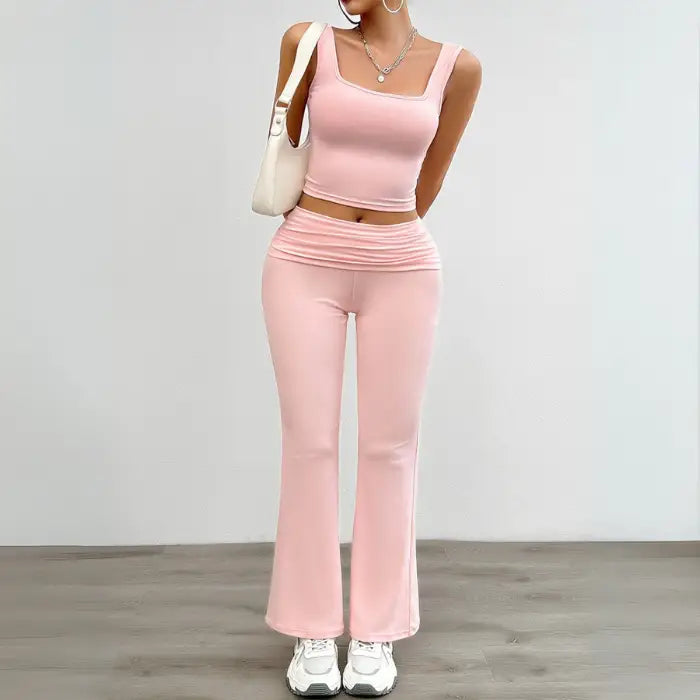 Stylish pink yoga two-piece set with a cropped tank top and high-waisted flared pants, ideal for yoga or casual wear.