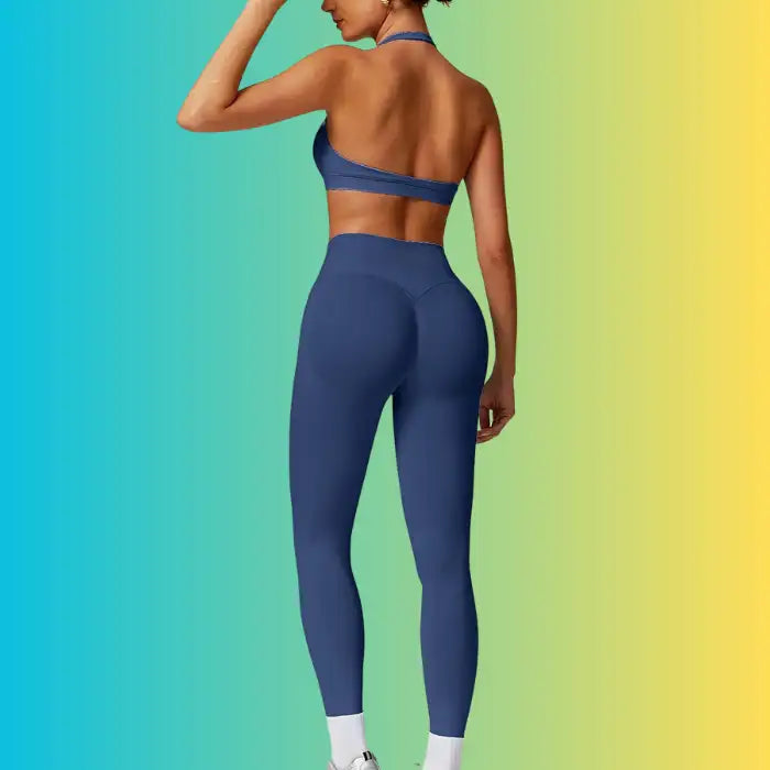 Yoga Workout Set in navy blue featuring back view of halter sports bra and body-hugging leggings.