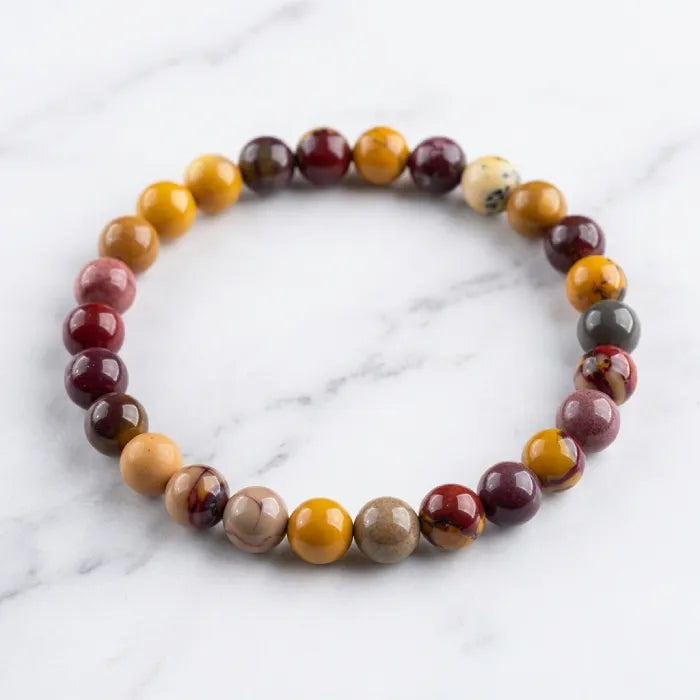 Yolk Stone Bracelet with polished round beads on marble surface, minimalist crystal jewelry for modern elegant styling