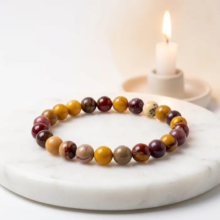 Yolk Stone Bracelet with polished beads beside candle, calming wellness jewelry ideal for relaxation and mindful lifestyle use
