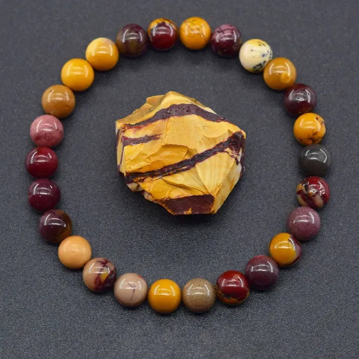 Yolk Stone Bracelet arranged around raw mookaite crystal, vibrant earthy tones jewelry promoting grounding energy balance