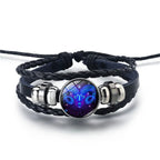 Zodiac Sign Bracelet with a vibrant Aries ram emblem glowing in deep blue shades, styled on braided leather for a bold celestial zodiac accessory.