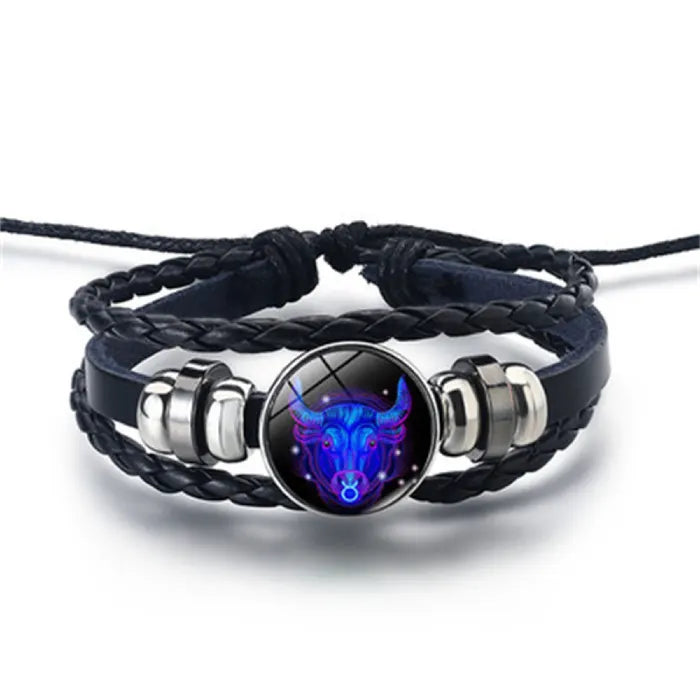 Zodiac Sign Bracelet showcasing a glowing Taurus bull emblem in cosmic blue tones, set on a braided leather band for meaningful zodiac-inspired style.