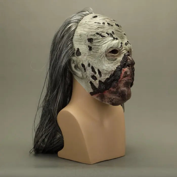 Zombie face mask in profile view, highlighting wrinkled pale skin and dark wounds.
