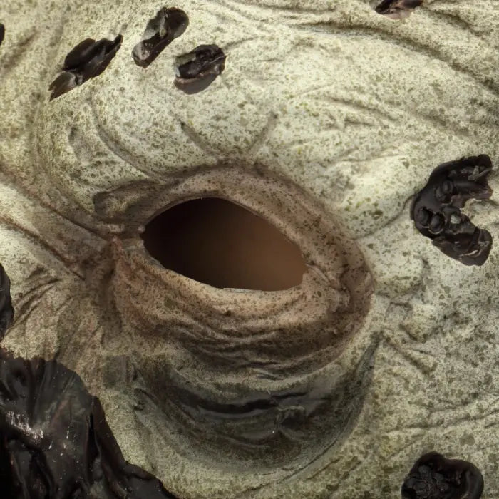 Zombie face mask featuring rotting eye socket with dark scabs and pale skin.