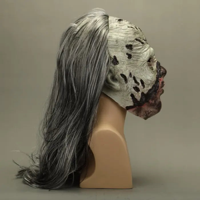 Zombie face mask side profile on mannequin, with long gray hair and decayed skin.